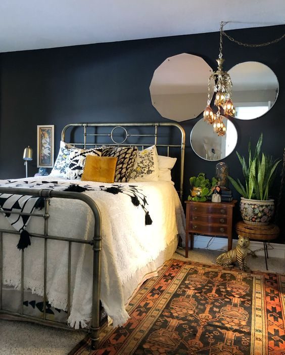 Photo of a dark painted bedroom with mirrors on the wall