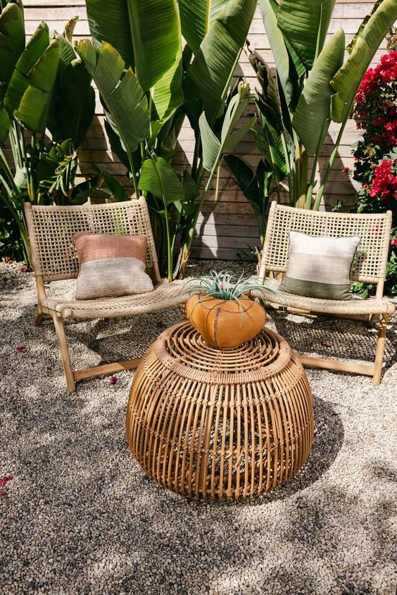 Rattan garden furniture with banana leaves in the background